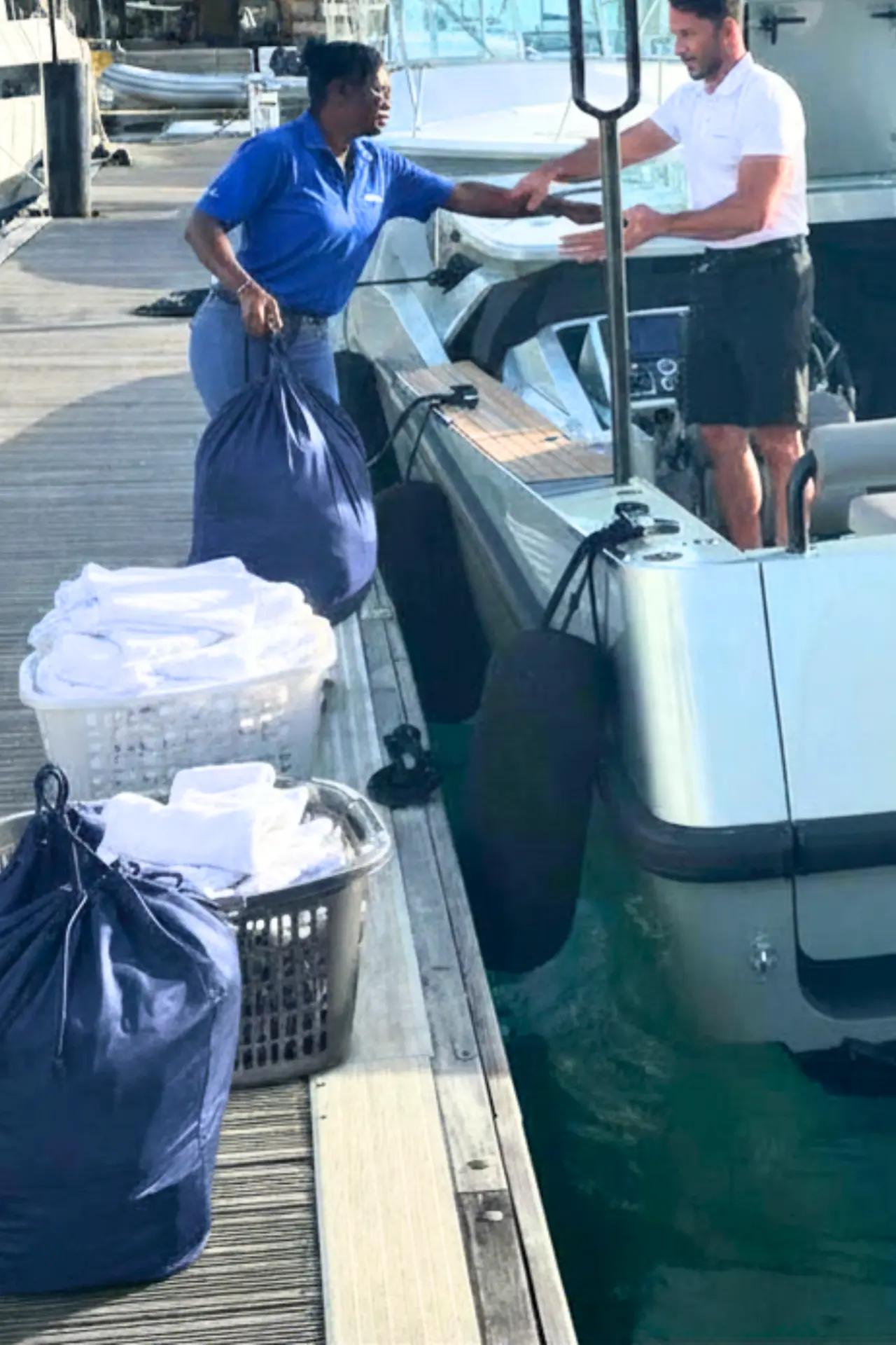 SVG Yacht Services agent handing laundry to a captain at the dock in the Grenadines