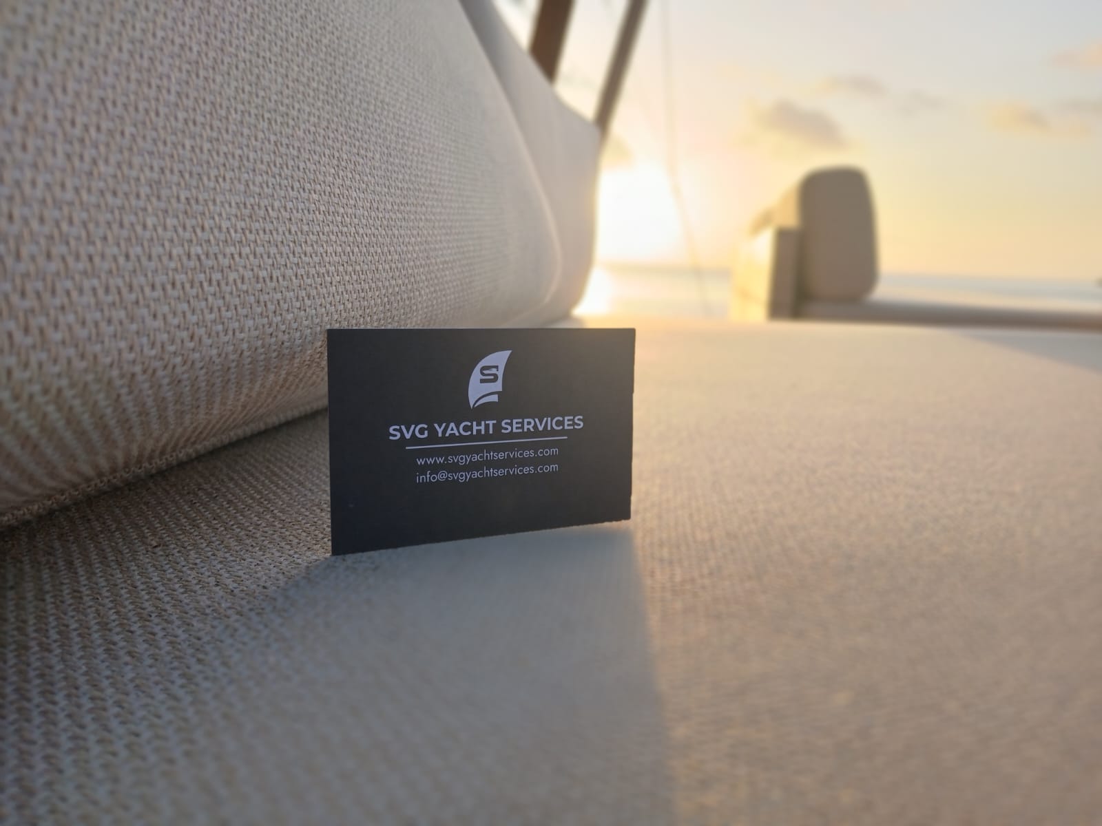 SVG Yacht Services business card on a yacht cushion at sunset